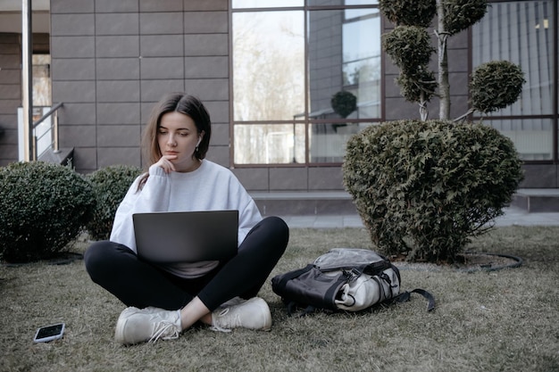 Trabalho ao ar livre Mulher trabalhando em laptop no parque Trabalho remoto distante durante a quarentena