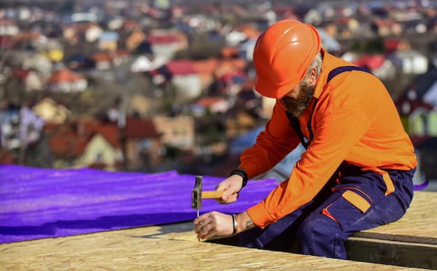 Trabalho de carpinteiro Ferramenta de trabalho de carpinteiro Indústria da construção e impermeabilização carpinteiro trabalhando na estrutura do telhado do prédio no canteiro de obras carpinteiro usa inspeção de uniforme de segurança
