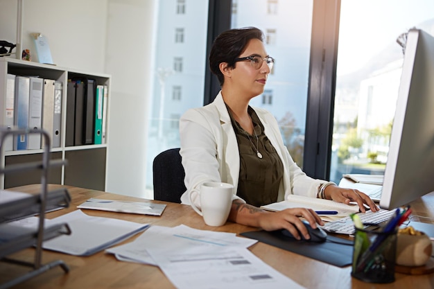 Trabalho de computador e mulher de negócios no escritório digitando documentos on-line pesquisa no site e escrevendo e-mail Redes corporativas e funcionária ocupada na mesa com planejamento de foco e ideias