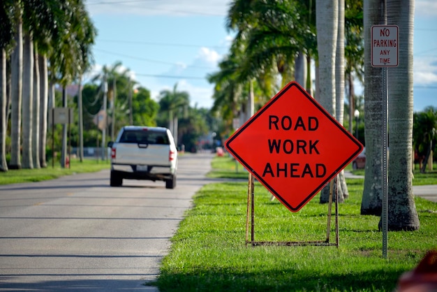 Trabalho de estrada à frente sinal no local da rua como aviso para carros sobre obras de construção e serviços públicos