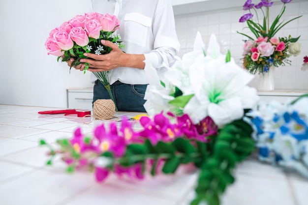 Trabalho de florista jovem, organizando a flor artificial diy, o artesanato e o conceito feito à mão.