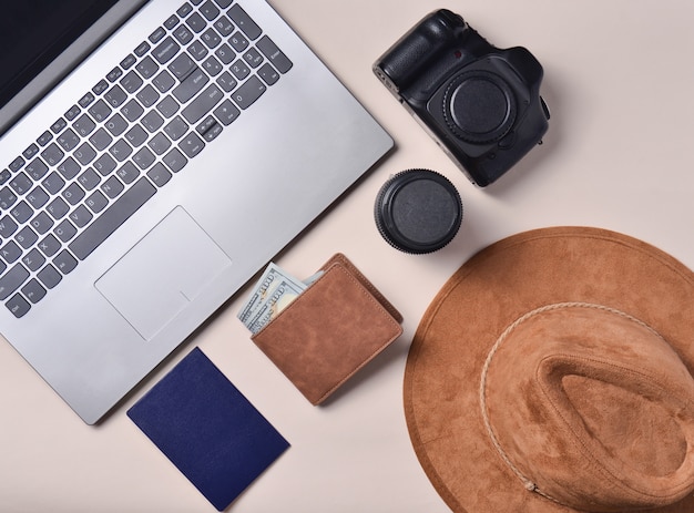 Trabalho do fotojornalista. Laptop, carteira, passaporte, chapéu, câmera, lente. Conceito de viagens, vista superior, plana leigos