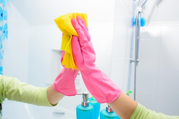 Foto trabalho doméstico de pessoas e conceito de limpeza mulher feliz limpando espelho com pano em casa