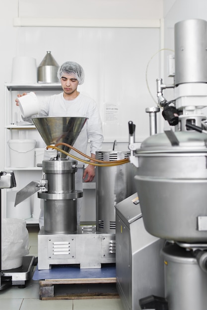 Foto trabalho dorme lascas de coco em um triturador industrial - prensa. produção de óleo de coco, pasta.