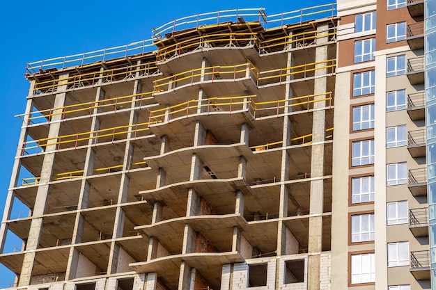 Trabalho em andamento em um novo bloco de apartamentos Edifício alto em construção Canteiro de obras do novo edifício