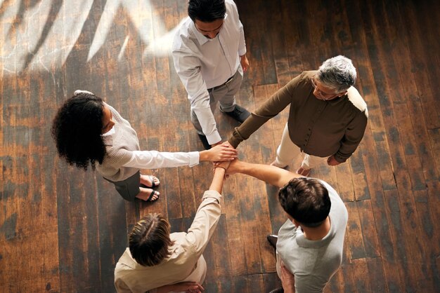 Foto trabalho em equipe acima e mãos de pessoas empilhadas para colaboração de apoio e missão de projeto para inicialização de negócios círculo de grupo de mulheres e homens juntos sinal de mão e metas da comunidade ou solidariedade de carreira