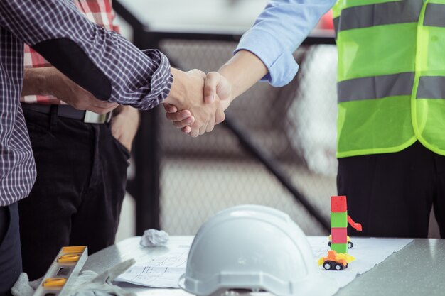 Trabalho em equipe, apertando as mãos no canteiro de obras