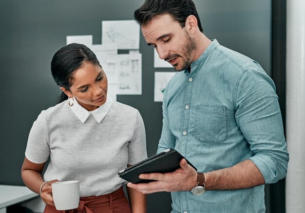 Trabalho em equipe de escritório e pessoas de negócios com tablet para pesquisa de arquitetura ou plano on-line para revisão Colaboração mulher e homem como arquitetos com plano de piso digital ou ideias para discussão