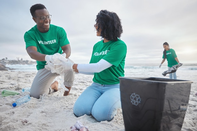 Trabalho em equipe feliz e reciclando com pessoas na praia para sustentabilidade, meio ambiente e ecologicamente correto Mudança climática, dia da terra e natureza com voluntários e plástico para ajudar a energia e poluição