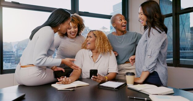 Trabalho em equipe mulheres felizes ou de negócios com telefone para fofocas notícias mídias sociais ou leitura de conteúdo de blog no escritório amigos startup ou grupo de funcionários em smartphone sorriso para networking ou comunicação