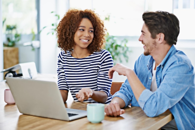 Foto trabalho em equipe no escritório e conversar com colegas de laptop na mesa ou tecnologia para conversação pessoas de parceria ou planejamento de carreira de design digital colaboração e sentar-se juntos em discussão