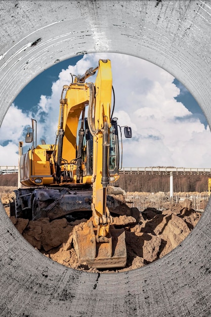 Trabalhos com rodas em um poço em um canteiro de obras A escavadeira realiza trabalhos de escavação no fundo de um céu nublado Vista da trincheira Preparação de um poço para construção