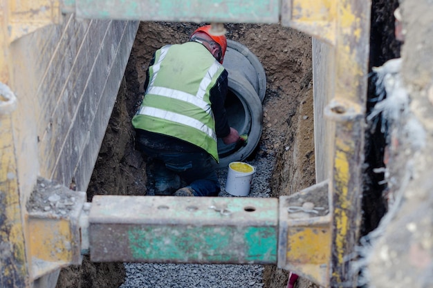 Trabalhos de drenagem profunda e terraplanagem instalando tubo de concreto protegido por sistema de suporte de vala