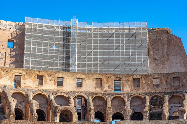 Foto trabalhos de reabilitação dentro do coliseu em roma com andaimes acima dos arcos abobadados na itália.