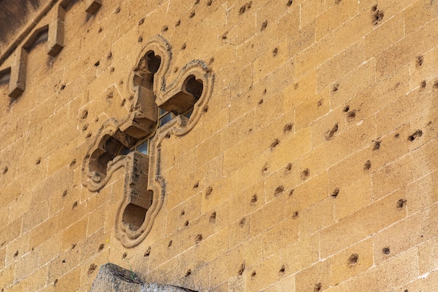 Traços de balas e estilhaços na parede de uma antiga igreja cristã