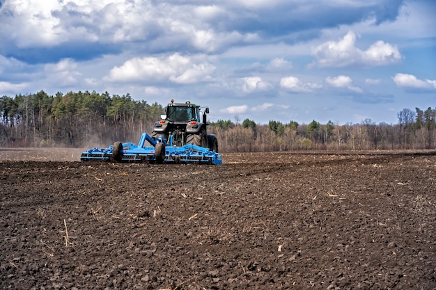 Tractor con agregado trabajando el suelo