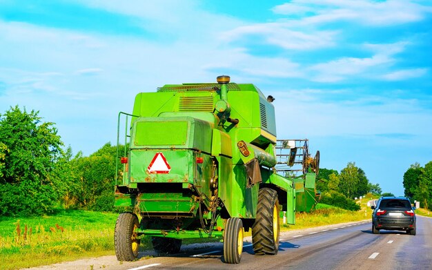 Tractor agrícola con remolque en carretera. Furgoneta de vehículos agrícolas en el trabajo en la entrada. transporte europeo. Transporte rural por carretera.