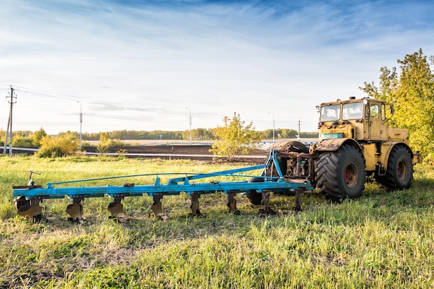 Tractor agrícola de ruedas con equipo de cosecha en un campo