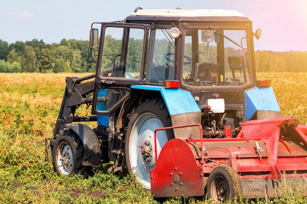 Tractor agrícola de ruedas moderno con equipo de cosecha en un campo