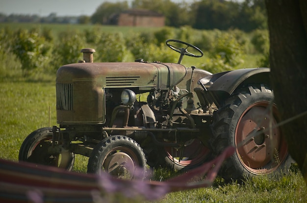 Foto tractor agrícola viejo oxidado y arruinado de las horas de trabajo realizadas durante los últimos 50 años. símbolo de la vida laboral en el campo.