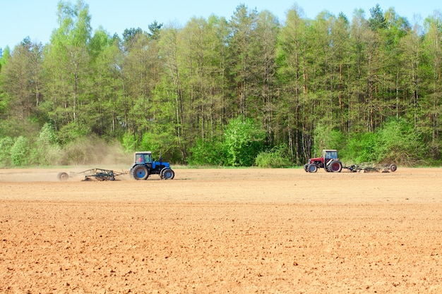 Tractor de arado durante el cultivo la agricultura trabaja en el campo con arado