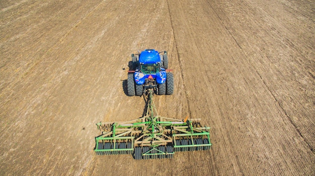 Un tractor arando y sembrando en el campo