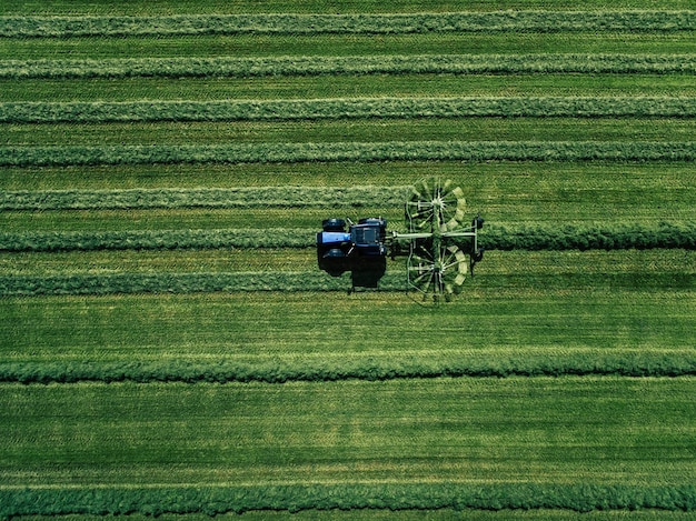Tractor azul cortando campo verde vista aérea Drone foto