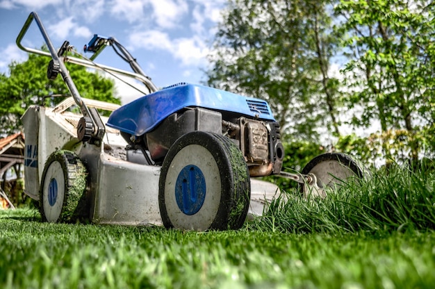 un tractor azul con una rueda azul está en la hierba