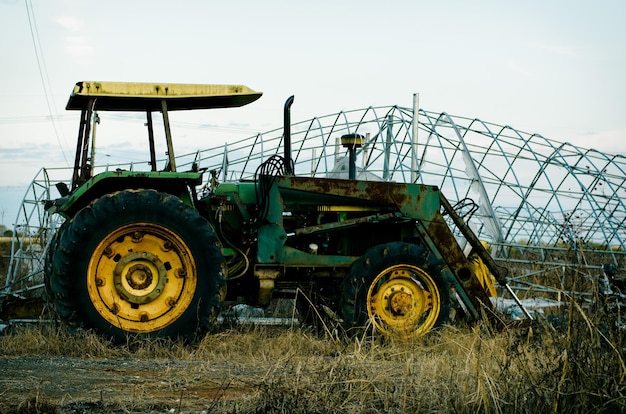 Tractor en el campo agrícola contra el cielo