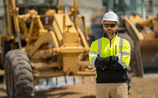 Tractor cargador de excavadora y constructor de trabajadores constructores con casco de casco en la construcción del sitio de construcción