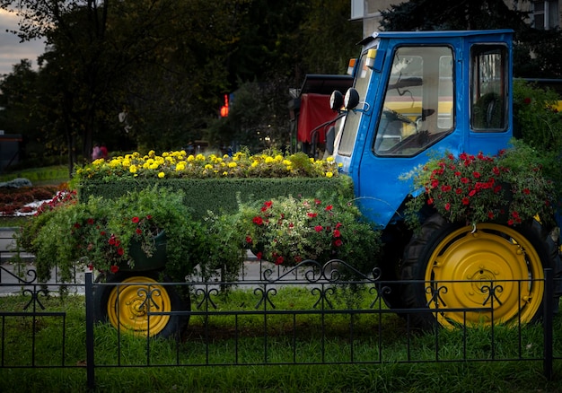 Tractor colgado con flores. Tecnología rural. Agricultura