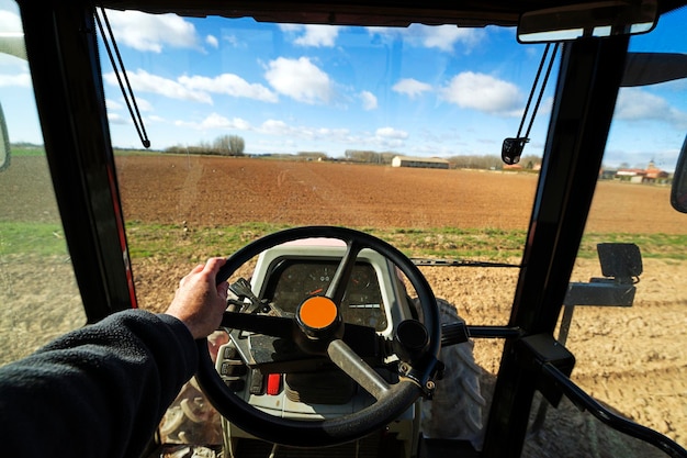 Foto tractor de conducción manual recortado en el campo agrícola