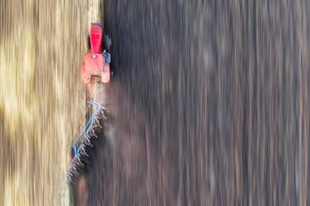 El tractor cultiva la vista del suelo desde el dron