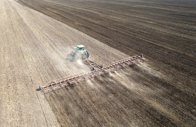 El tractor cultiva la vista del suelo desde el dron