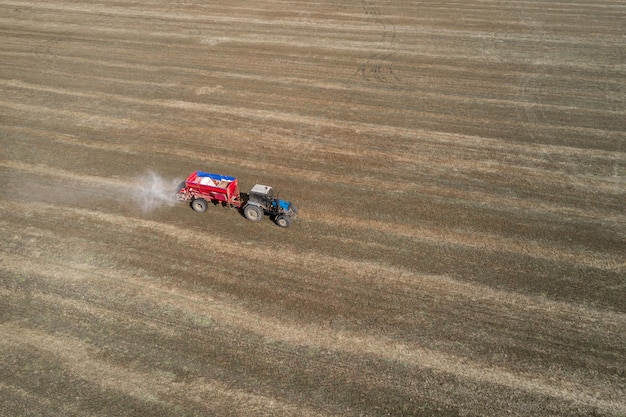 Tractor esparciendo fertilizantes artificiales en el campo