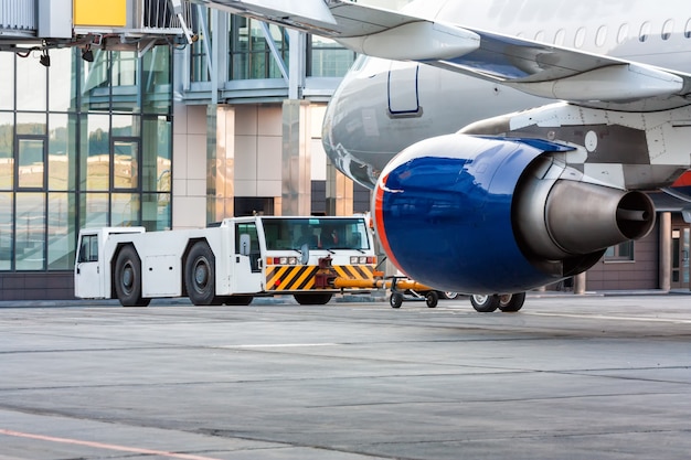 El tractor está remolcando el avión de pasajeros.