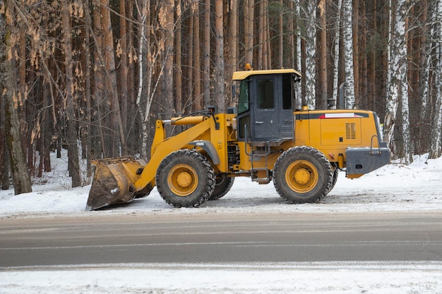 Tractor con implementos montados quita nieve en invierno en la ciudad