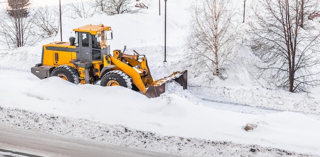 El tractor de limpieza de nieve despeja el camino después de fuertes nevadas