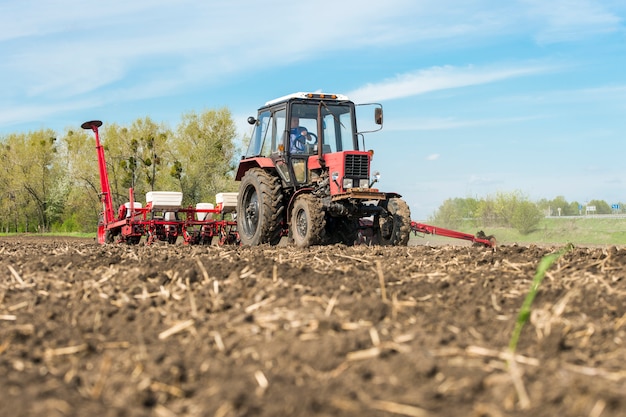 Foto tractor con maceta en el campo con cielo azul