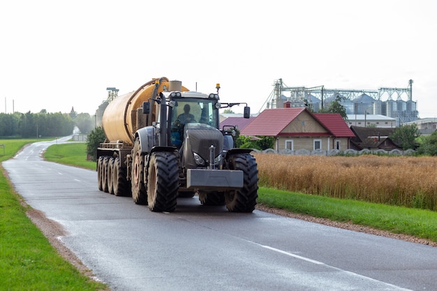 Un tractor con un moderno remolque de fertilizantes.