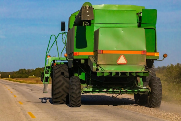 Foto tractor na estrada por campo agrícola contra o céu