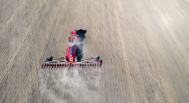 Un tractor prepara la tierra con un cultivador de siembra en tierras agrícolas.