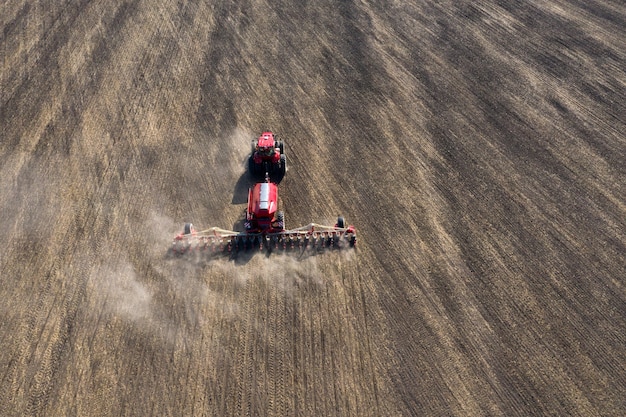 Un tractor prepara la tierra con un cultivador de siembra en tierras agrícolas.