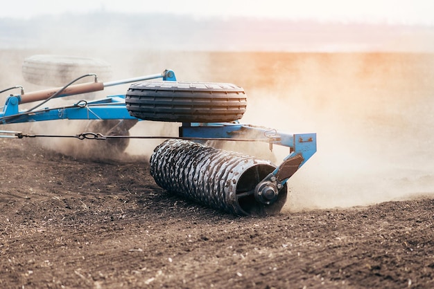 El tractor procesa el campo en la cosechadora de primavera en el trabajo de siembra de cultivos de trigo y cerealesxA