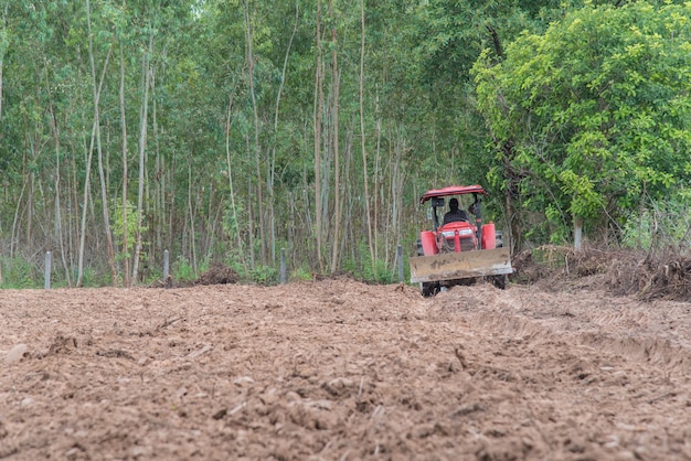 Tractor que ara el suelo en el jardín para el crecimiento vegetal.