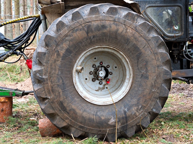 Foto el tractor que recoge los árboles talados se encuentra lateralmente con la rueda de cerca