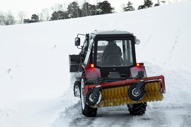 El tractor quita la nieve de la carretera en invierno