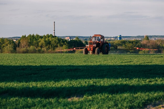 Tractor rociando pesticidas en los campos