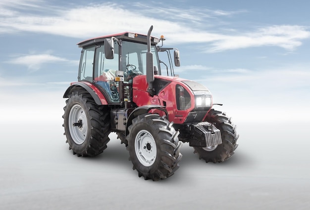 Tractor de ruedas moderno rojo aislado sobre fondo brillante con cielo