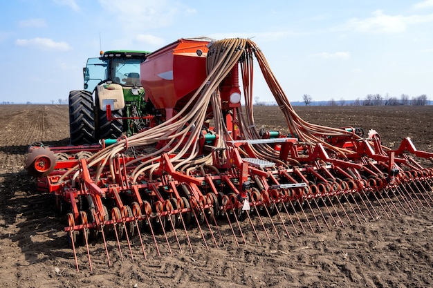 Tractor con sembradora en el campo a principios de la primavera